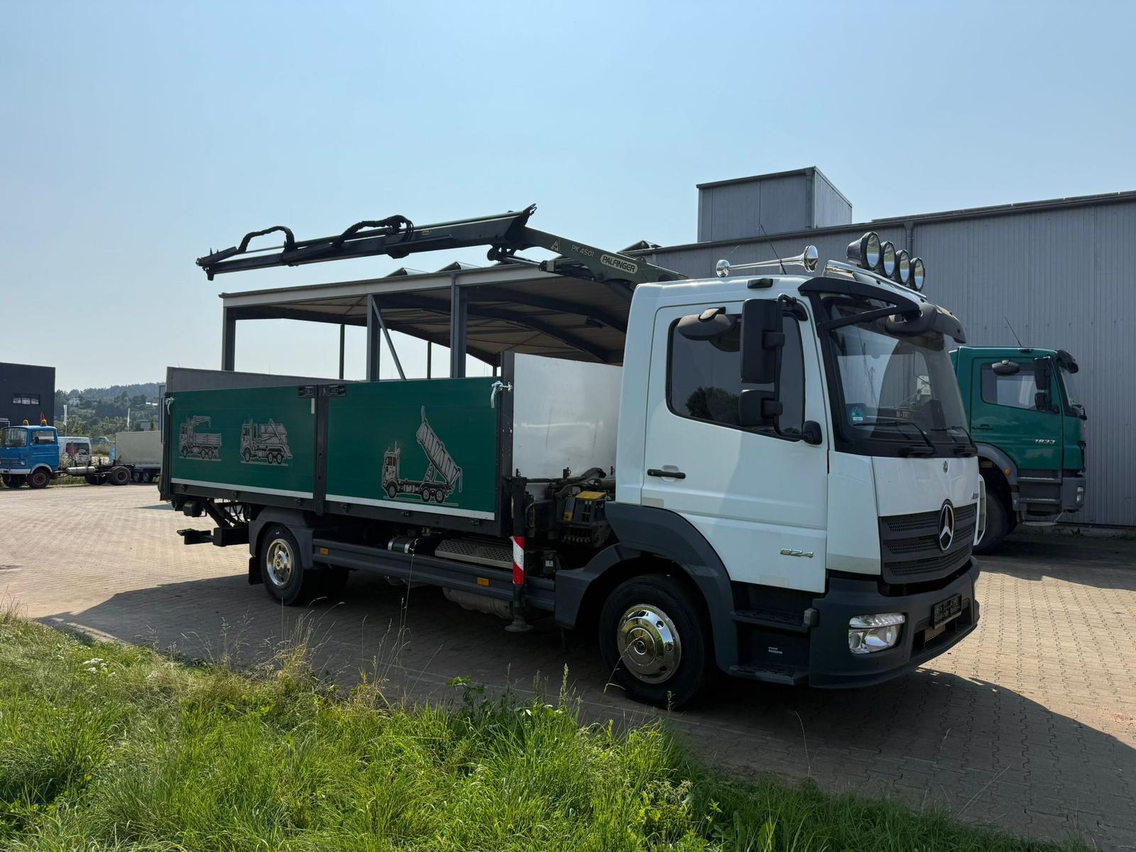 Zijkant van de vrachtwagen van Wout Oudijzer met groene laadbak en laadkraan